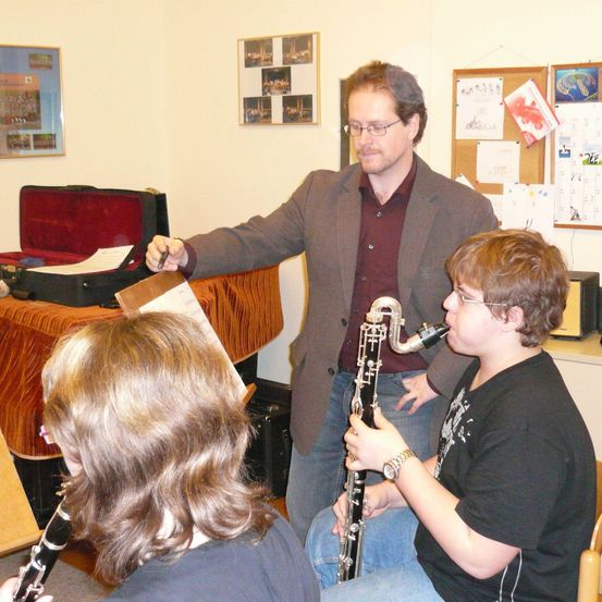 Bild enthält, Oboe, Boy, Male, Person, Teen, Clarinet, Chair, Wristwatch, Adult, Man