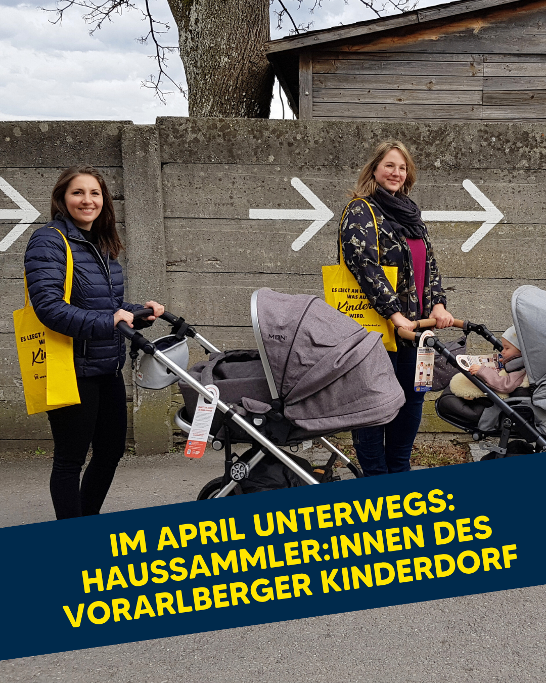 Zwei Frauen stehen mit Kinderwagen, eine hält ein Baby, in der Nähe einer Betonmauer mit Pfeilen. Die Frauen lächeln und tragen gelbe Taschen.