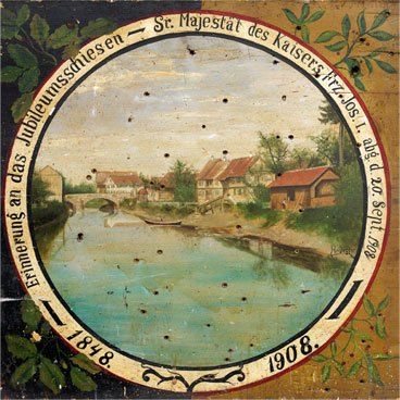 Ein altes Gemälde eines Dorfes mit einem Fluss und Häusern, datiert 1848 und 1908. Das Kunstwerk hat eine kreisförmige Rahmung mit einem Titel in Deutsch.