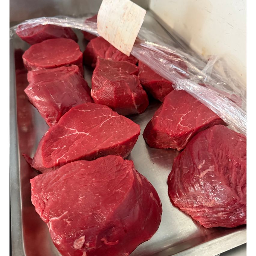 Ein Tablett mit rohen Rindersteaks, in Plastik eingewickelt, bereit zum Verkauf.