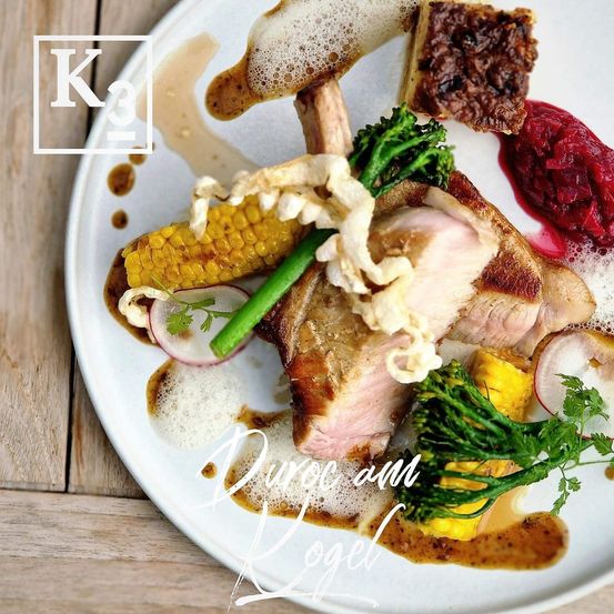 Ein Teller mit Entenbrust, Mais, Brokkoli und Rote Bete. Das Gericht ist mit Saucen und Garnierungen verfeinert.