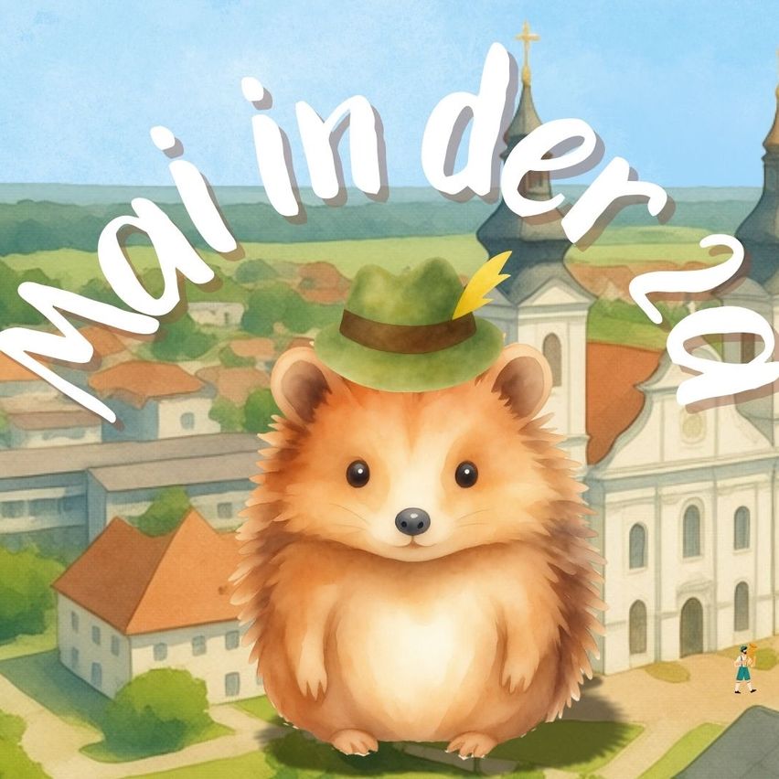 Ein Igel mit einem grünen Hut mit einer gelben Feder steht vor einer Kirche und Häusern. Die Wörter Mainder 2 sind oben.