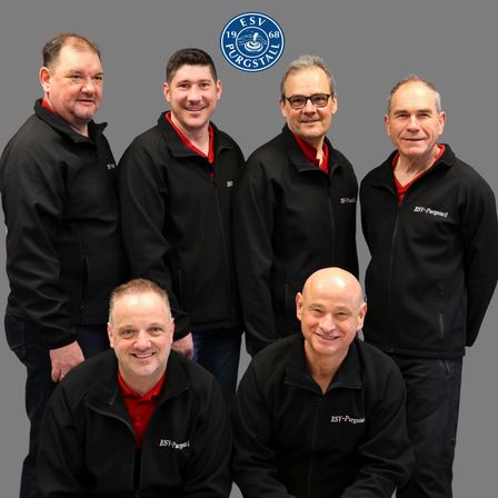 Sechs Männer in schwarzen Jacken mit roten Kragen posieren für ein Foto. Das Logo 'ESV 68 PURGSTALL' ist über ihnen sichtbar.