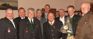 Eine Gruppe von Männern in traditioneller Kleidung steht zusammen, ein Mann hält eine Trophäe, andere tragen Medaillen, die Bildunterschrift lautet OKB-Vorstand mit Bez-Kommandant.