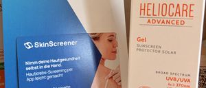 Zwei Sonnencremeprodukte sind ausgestellt. Eines ist SkinScreener mit blauer Abdeckung. Das andere ist Heliocare Advanced mit weißer Abdeckung.