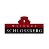 Das Logo für Weingut Schlossberg ist auf einem weißen Hintergrund zu sehen. Es zeigt ein rotes Schloss mit zwei Türmen, einem schwarzen Banner und dem Text 'Weingut Schlossberg' in großen, roten, großgeschriebenen Buchstaben.
