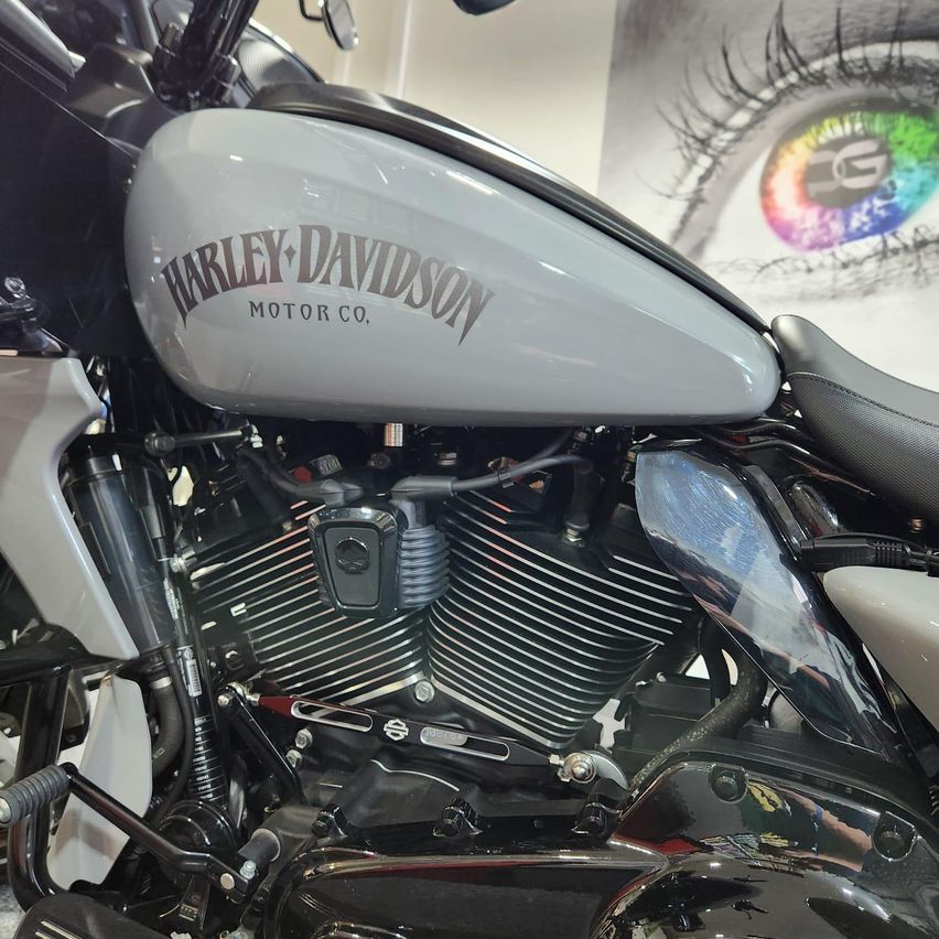 Ein Nahaufnahme eines Harley-Davidson Motorrads mit sichtbarem Motor und Teilen, ausgestellt in einem Ausstellungsraum.
