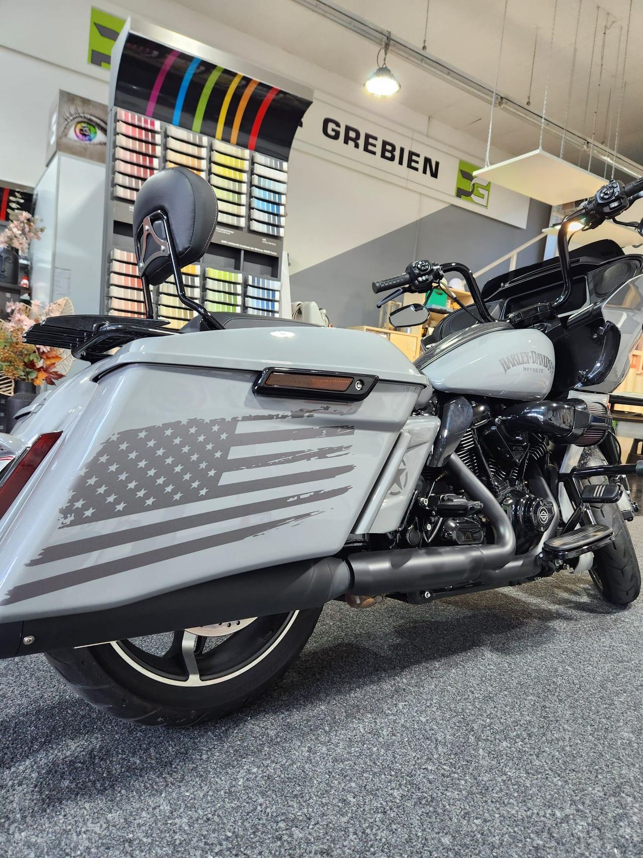 Ein Harley-Davidson Motorrad mit einem amerikanischen Flaggendesign auf der Seite ist in einem Ausstellungsraum geparkt.