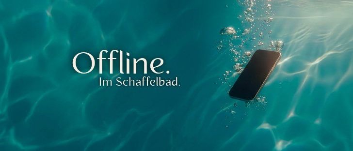 Eine Unterwasserszene zeigt ein Telefon mit den Worten 'Offline.' und 'Im Schwimmbad.' auf einem blauen Hintergrund mit Blasen.