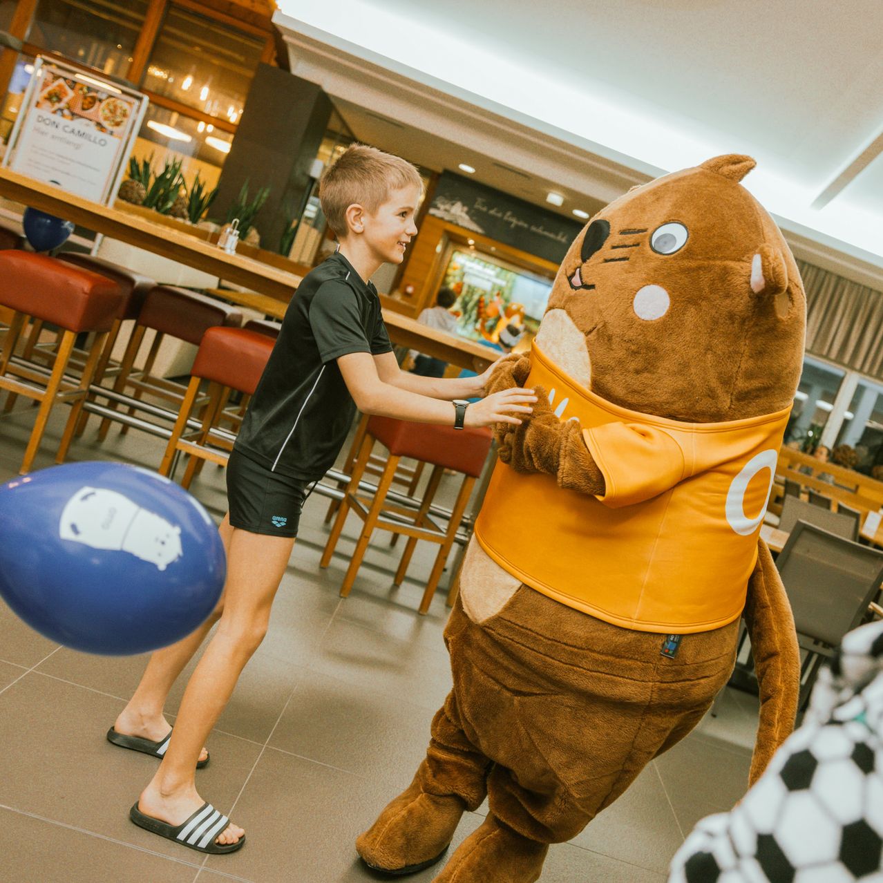 Bild enthält, Shorts, Person, Shoe, Mascot, Adult, Male, Man, Indoors, Table, Face