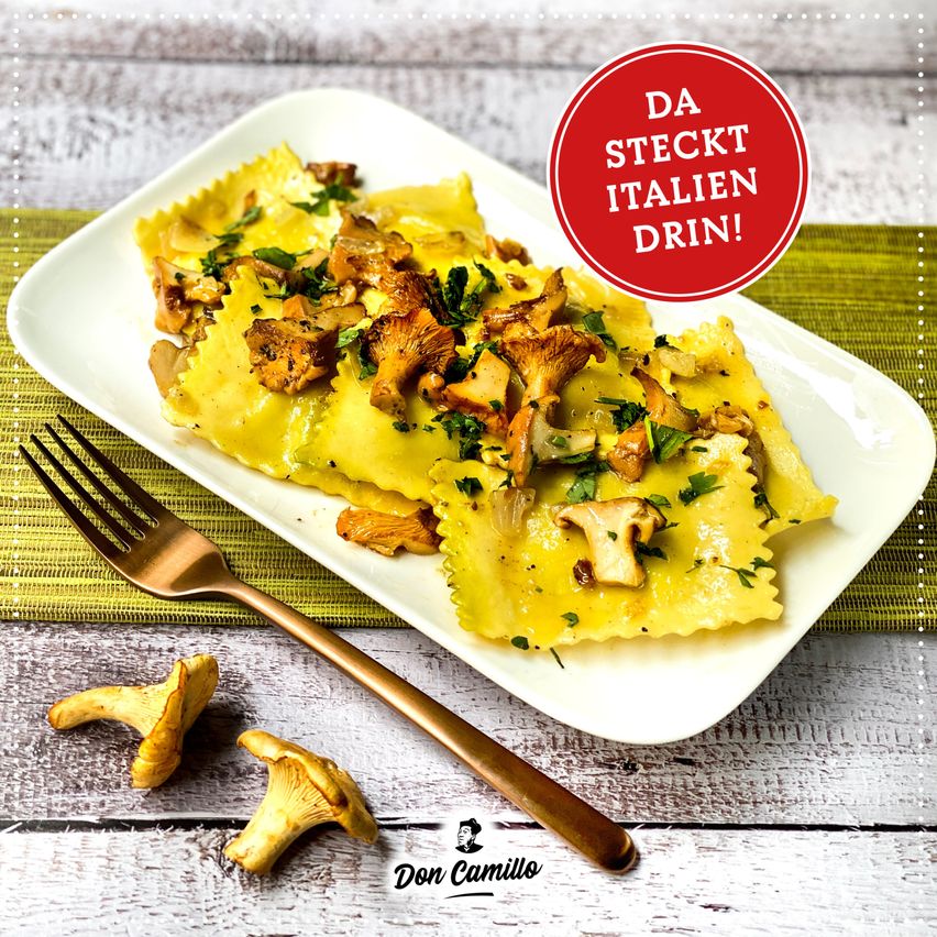 Ein Teller mit Ravioli mit Pilzen, betoppt mit Kräutern, auf einem Holztisch mit einer Gabel und einem roten Kreis mit den Worten Da steckt Italian Drin! in der Mitte.