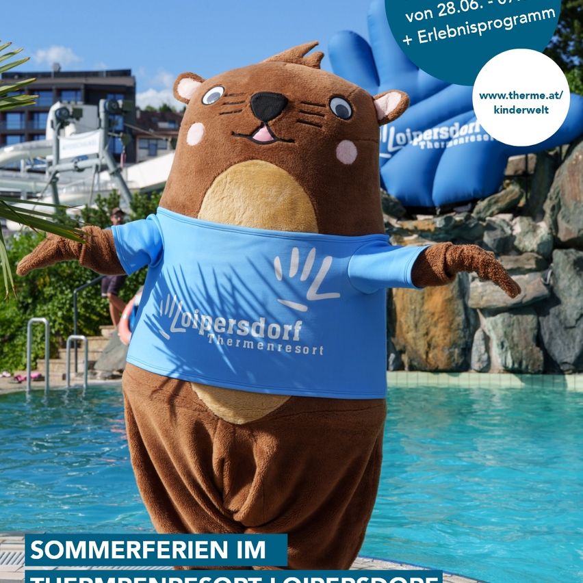 Ein Maskottchen, das als Biber verkleidet ist und ein blaues T-Shirt trägt, steht in einem Schwimmbecken mit einer Felswand und Wasserrutschen im Hintergrund.