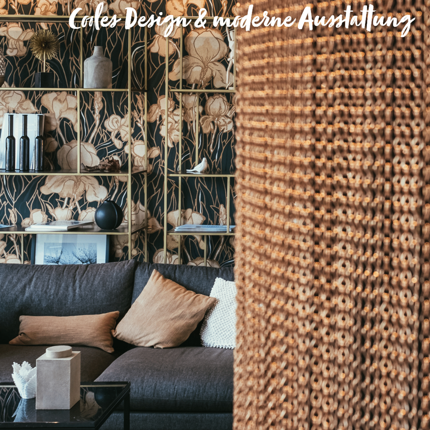 Ein modernes Wohnzimmer mit einem grauen Sofa, dekorativen Kissen und einer goldfarbenen Wand mit Blumentapete. Eine strukturierte Lampe befindet sich auf der rechten Seite.