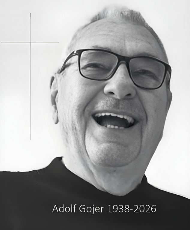 Ein schwarz-weißes Porträt von Adolf Gojer, der eine Brille trägt und lächelt. Geboren 1938 und verstorben 2026.