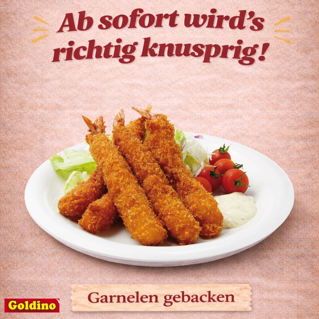 Ein Teller mit knusprigen Garnelen, Salat und Tomaten, begleitet von einer weißen Sauce, mit dem Markennamen 'Goldino' unten sichtbar.