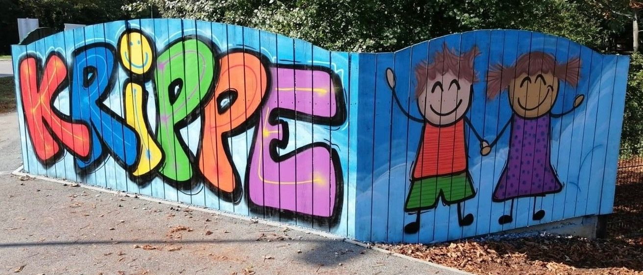 Ein blau gestrichener Holzzaun mit bunten Graffitis, die das Wort Ripple ergeben. Zwei Cartoon-Kinder halten Händchen. Im Hintergrund ist ein verschwommener grüner Baum.