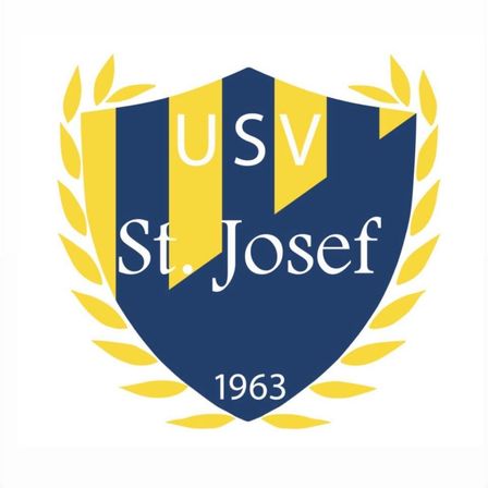 Das blau-gelbe Logo des USV St. Josef, gegründet 1963. Der Name und das Jahr sind auf einem weißen Schild mit dekorativen Blättern abgebildet.