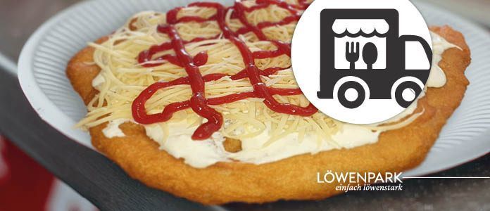 Ein Nahaufnahme eines Gerichts auf einem weißen Teller mit einem Logo für Lieferung oben. Das Gericht scheint eine Käsepizza zu sein, die mit geriebenem Käse und rotem Ketchup belegt ist.