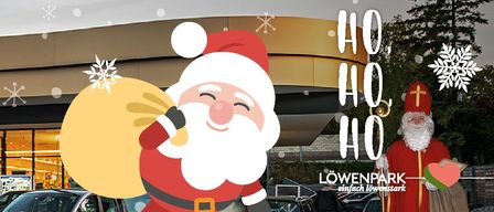 A Santa Claus figure carrying a sack with a snowflake is in front of a building, with a Christmas tree and a red cross symbol.