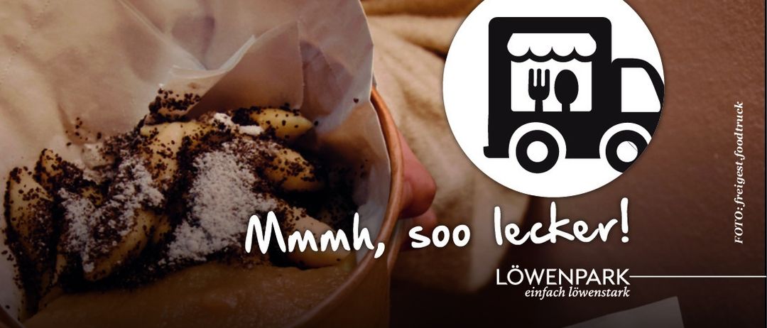 A person holds a paper bag with food inside. The food appears to be a dish with potato pieces and sprinkled toppings. A logo of a truck with utensils is in the corner. The text reads 'Mmmh, soo lecker!' and 'Lowenpark-einfach lowenstark'.