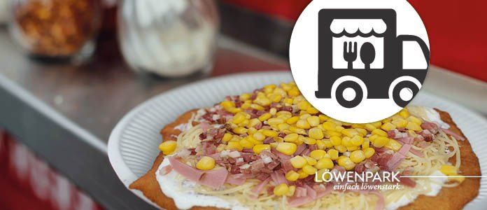 Ein Teller mit einer runden Beilage, überzogen mit Käse, Mais und Schinken, mit einem Lieferwagen-Logo an der Seite.