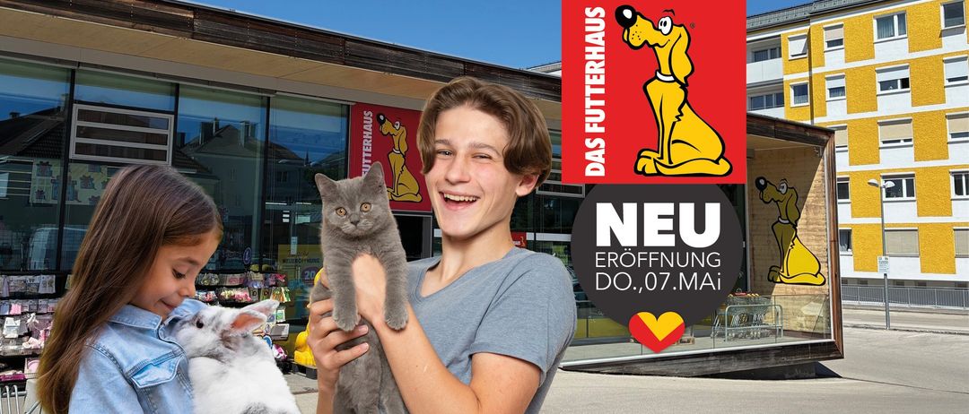Ein junger Mann hält eine graue Katze vor einem Tierladen mit einem Hundemaskottchen. Der Laden hat eine Neueröffnung am Donnerstag, 7. Juli.