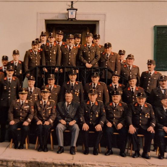 Eine Gruppe uniformierter Militäroffiziere posiert für ein Foto vor einem Gebäude.