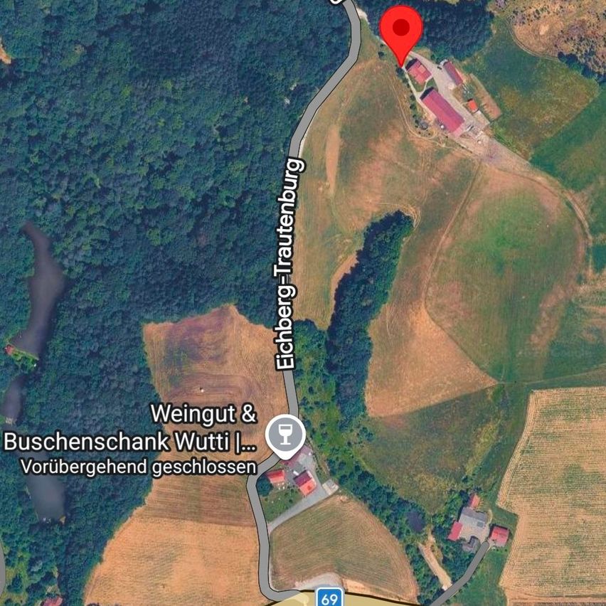 Luftaufnahme eines Weinguts und einer Weinkellerei in Eichberg-Trautenburg. Der Standort ist mit einem roten Pin markiert. Das Gebiet ist von landwirtschaftlichen Flächen umgeben.