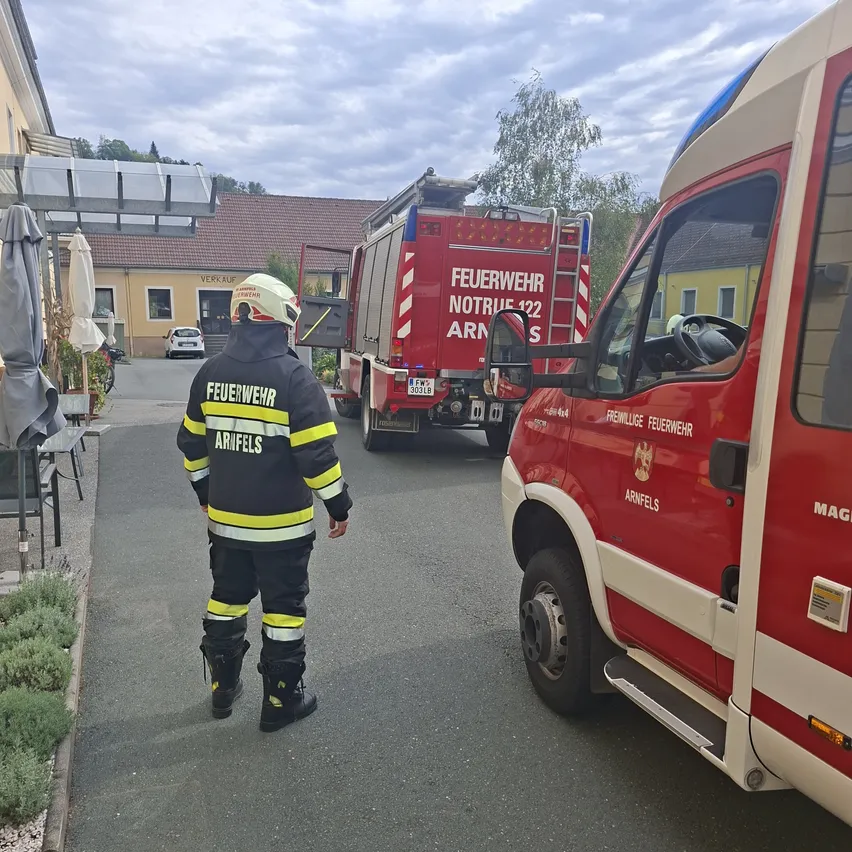 Ein Feuerwehrmann in voller Ausrüstung geht an einem geparkten Feuerwehrwagen vorbei. Der Feuerwehrwagen hat die Nummer 122 auf seiner Seite.