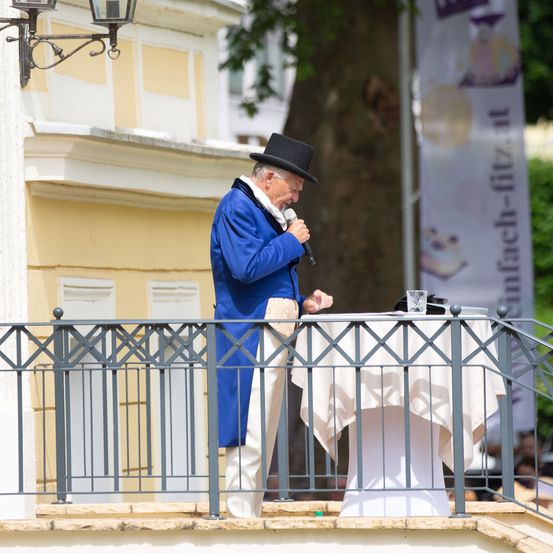 Handrail, Railing, Coat, Adult, Male, Man, Person, Hat, Formal Wear, Microphone