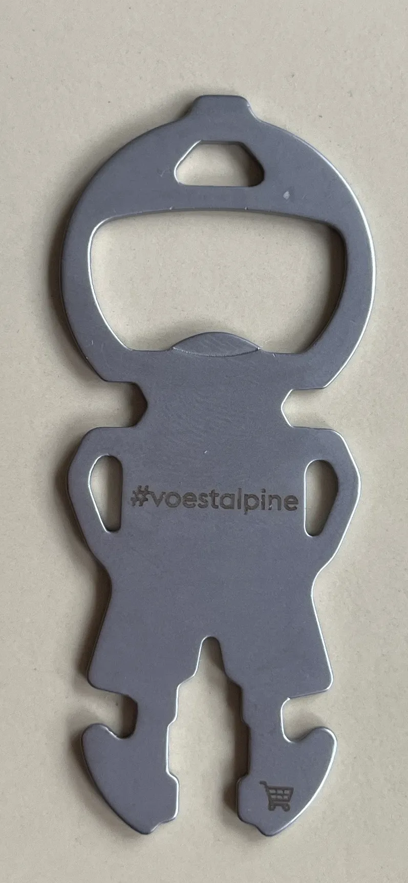 Ein metallischer Dosenöffner in Form einer menschlichen Figur mit '#voestalpine' darauf geschrieben.