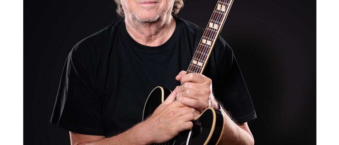 Peter Cornelius, ein Mann mit Brille, hält eine Gitarre und trägt den Text 'Live 2025' oben. Das Poster ist für ein Konzert im Naturpark Südsteiermark, mit dem Datum '21.8.25' und der Zeit '20:00 Uhr'.