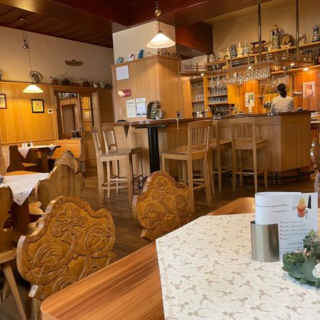 Bild enthält, Person, Painting, Wood, Interior Design, Chair, Bar, Lamp, Dining Table, Monitor, Cup