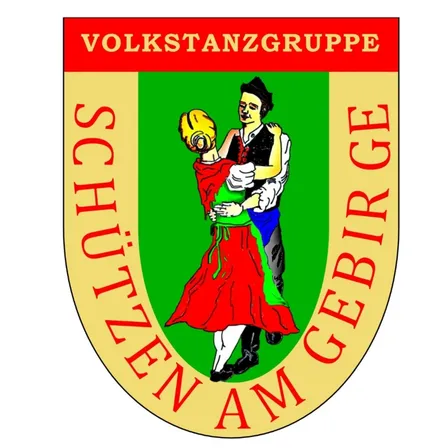 Ein Logo mit einem tanzenden Mann und einer Frau, umgeben von dem Text 'VOLKSTANZGRUPPE SCHUTZEN AM GEBIRGE'.