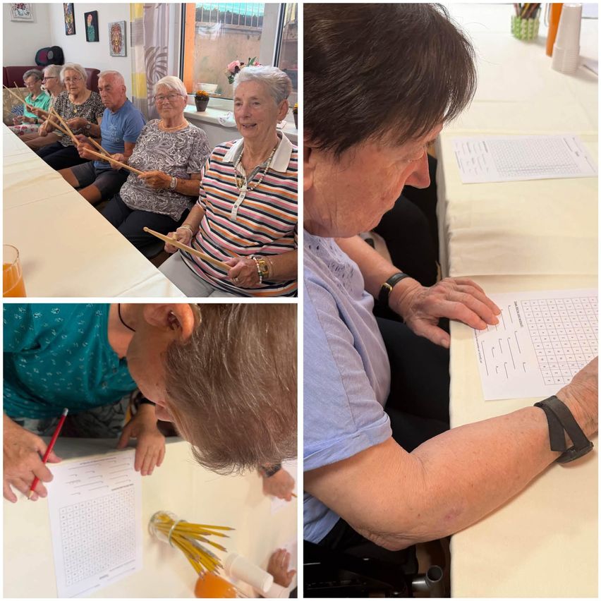 A group of elderly individuals are seated at a table, some are holding drumsticks and others are engaged in a puzzle activity.