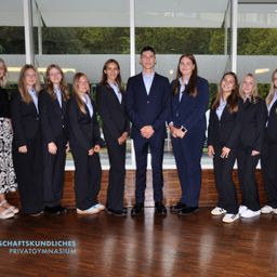 Bild enthält, Groupshot, Person, Wood, Floor, Flooring, Hardwood, Formal Wear, Suit, Adult, Woman