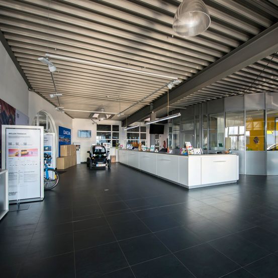 Bild enthält, Floor, Flooring, Architecture, Building, Indoors, Car, Car Dealership, Wheel, Interior Design, Person