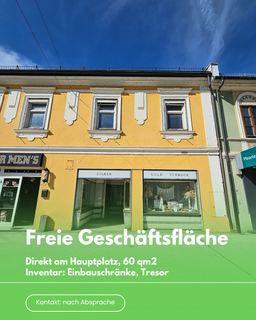 Ein gelbes Gebäude mit drei Fenstern und einem Banner mit der Aufschrift 'Freie Geschäftsfläche'. Das Gebäude hat einen Laden mit Schildern für Silber und Gold Schmuck. Der Laden hat eine Glastür und ein Glasfenster mit Gegenständen im Inneren.