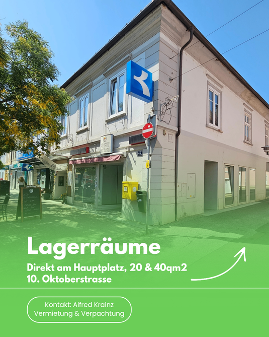 Eine Werbung für Lagerräume direkt am Hauptplatz, mit einem Gebäude, einem blauen Pfeil und dem Text 'Lagerräume Direkt am Hauptplatz, 20 & 40qm2 10. Oktoberstrasse'.