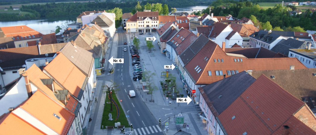 Luftaufnahme einer Stadt mit nummerierten Straßenkreuzungen, Gebäuden und einem Fluss im Hintergrund.