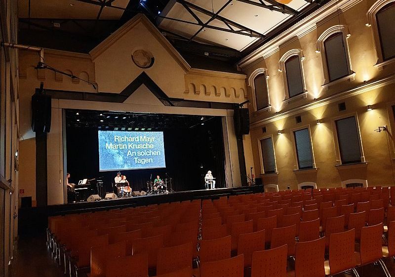 Bild enthält, People, Person, Indoors, Theater, Building, Cinema, Auditorium, Hall, Stage, Lighting