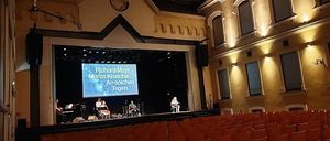 Bild enthält, People, Person, Indoors, Theater, Building, Cinema, Auditorium, Hall, Stage, Lighting