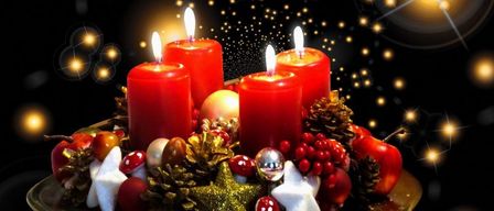 Vier rote Kerzen brennen auf einem goldenen Teller, umgeben von Ornamenten und Tannenzapfen. Der schwarze Hintergrund hat gelbe Lichter in der Ferne.