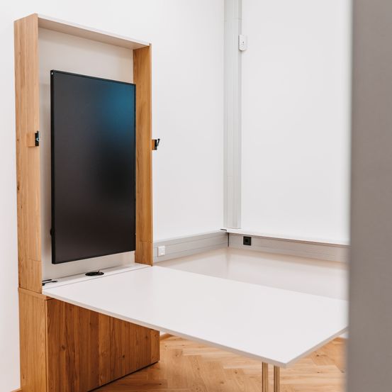 Bild enthält, Interior Design, Furniture, Table, Wood, Floor, Plywood, Desk, Flooring, Screen, Monitor