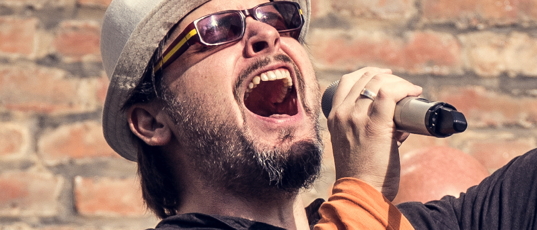Bild enthält, Sunglasses, Head, Person, Face, Finger, Adult, Male, Man, Microphone, Hat