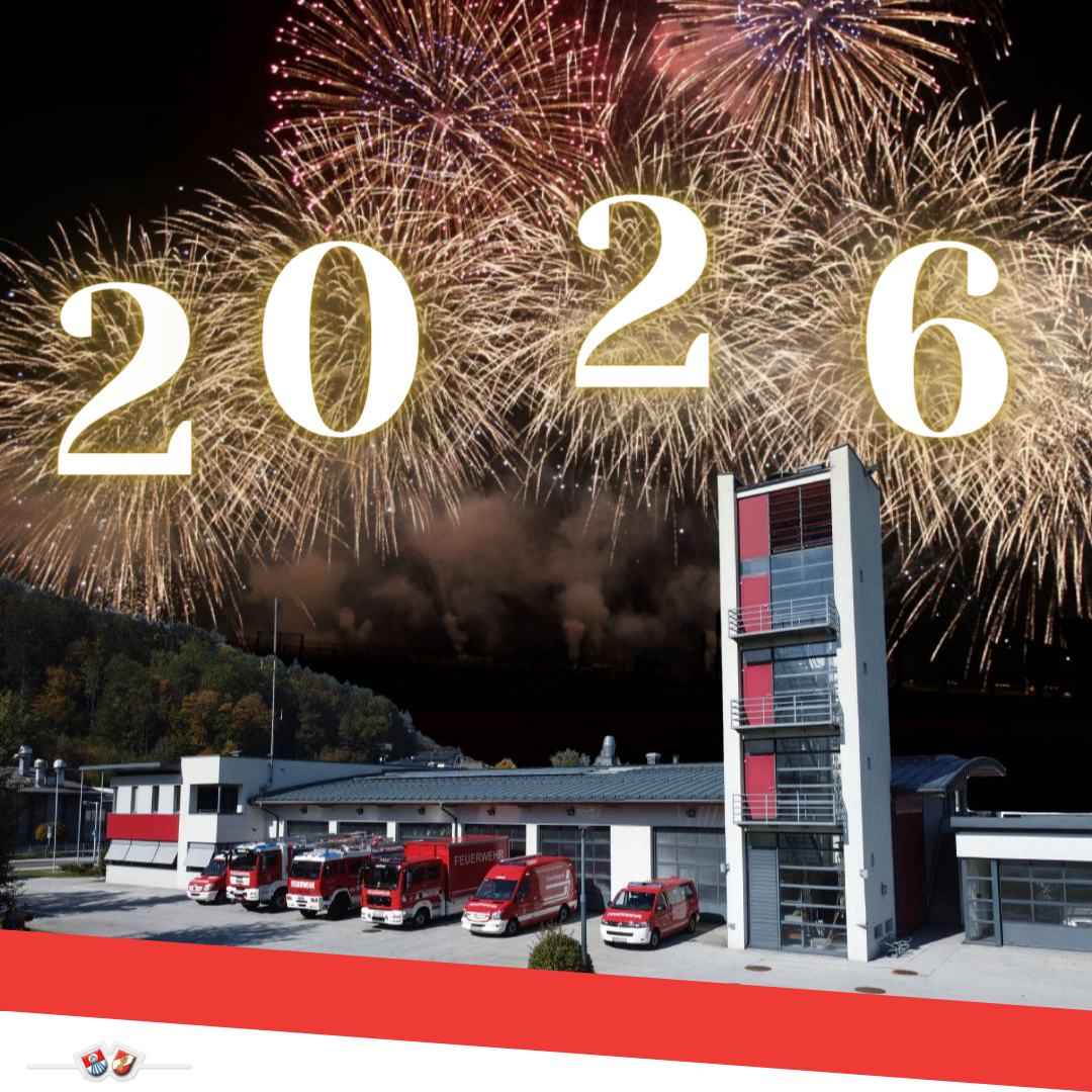 Feuerwache mit mehreren Feuerwehrfahrzeugen davor. Das Jahr 2026 ist in weißen Zahlen über der Wache angezeigt. Feuerwerke erhellen den Himmel.