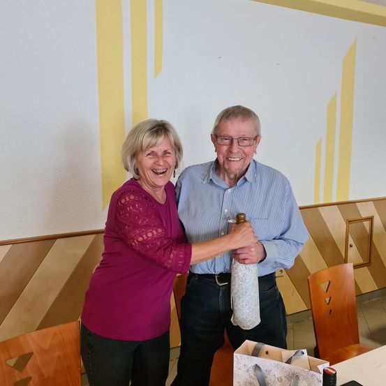 Bild enthält, Person, Photography, Portrait, Dining Room, Dining Table, Table, Blouse, Pants, Wood, Couch