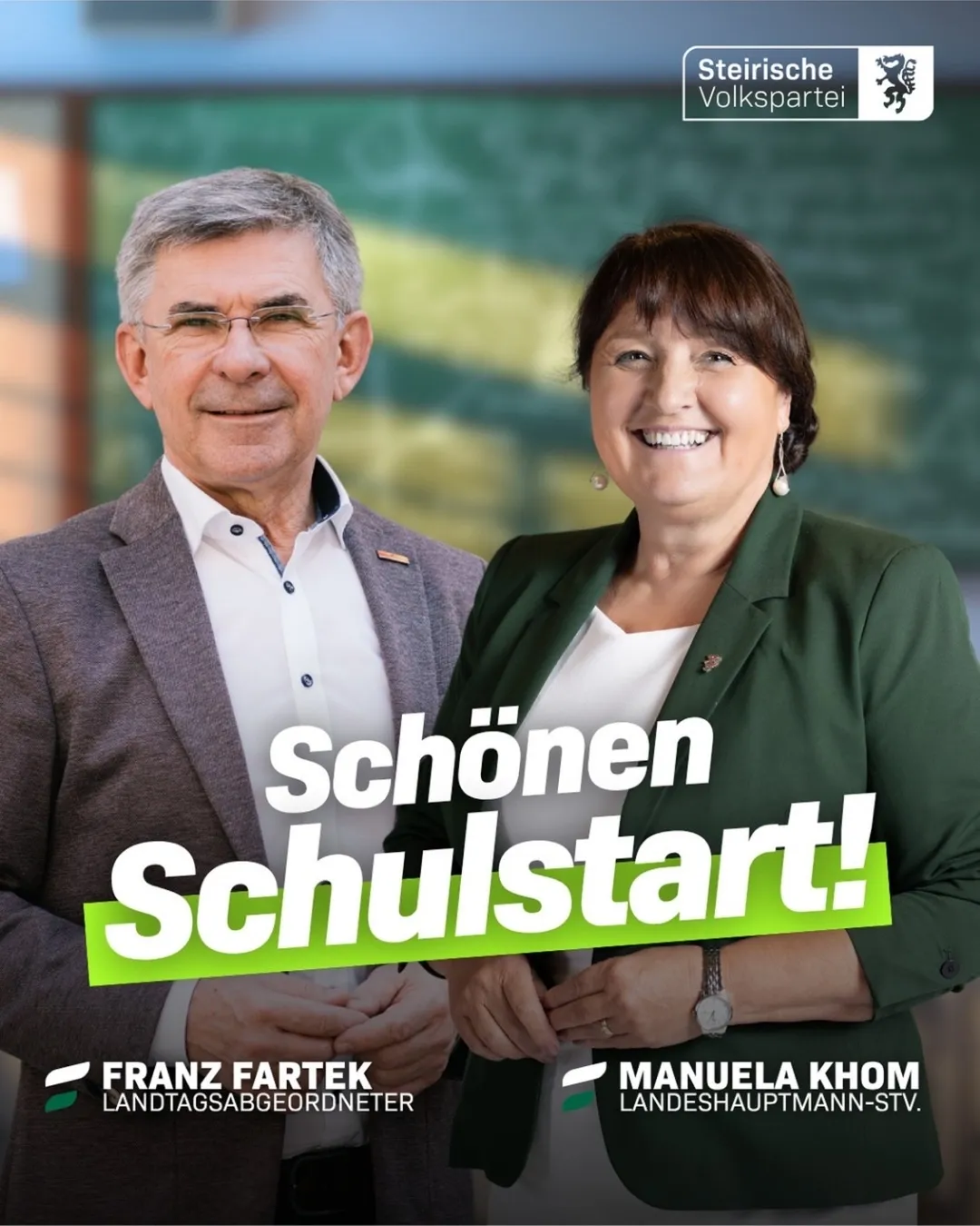 Ein Mann und eine Frau lächeln und stehen zusammen, in formeller Kleidung. Der Mann trägt eine Brille und einen Anzug, während die Frau einen grünen Blazer und ein weißes Hemd trägt. Sie stehen vor einem grünen Hintergrund mit dem Text 'Schönen Schulstart!' in Weiß geschrieben.