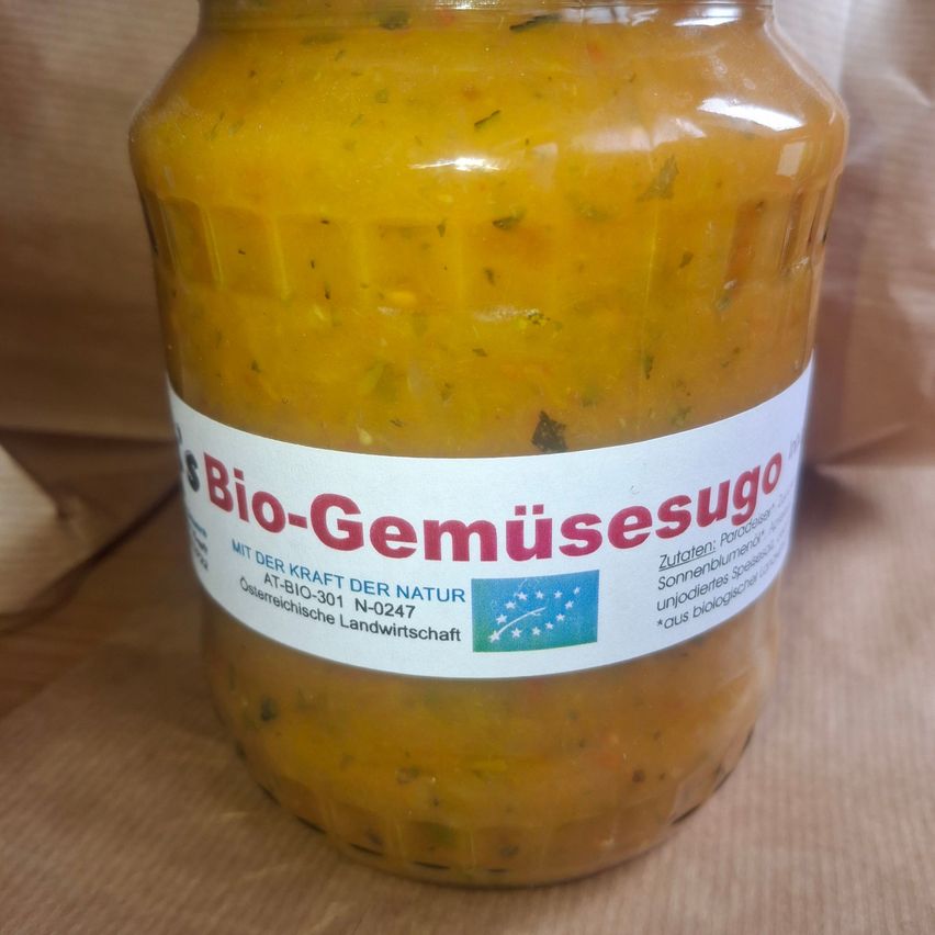 Ein Glas mit gelber, klumpiger Gemüsepaste, beschriftet mit 'Bio-Gemuseesugo'. Das Etikett enthält den Markennamen, eine EU-Bio-Zertifizierung und die Zutaten.