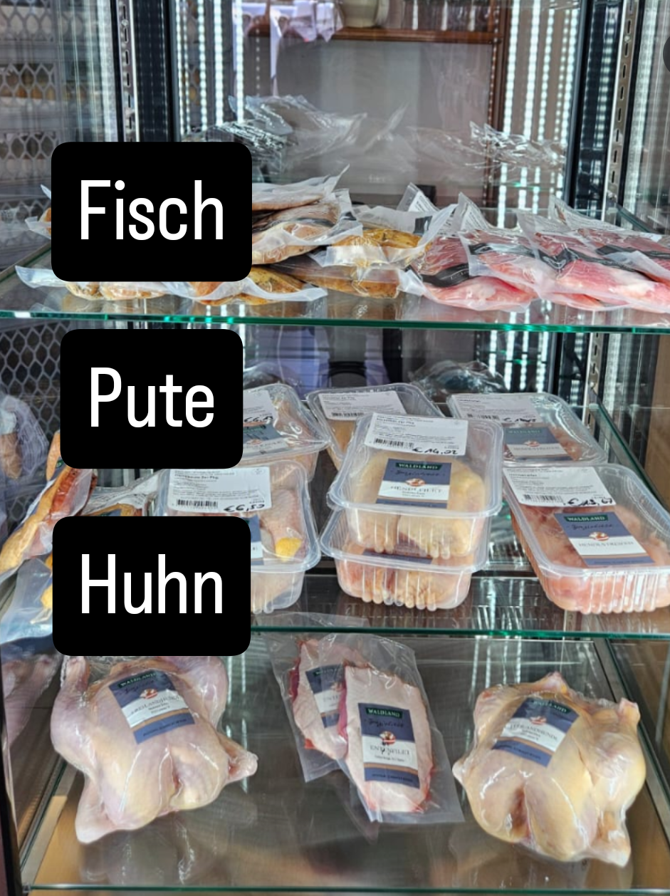 Ein Gefrierschrank mit Glasfront, gefüllt mit verschiedenen Fleischsorten. Obere Reihe: Fisch, Pute und Huhn. Untere Reihe: Huhn in Plastikverpackungen.